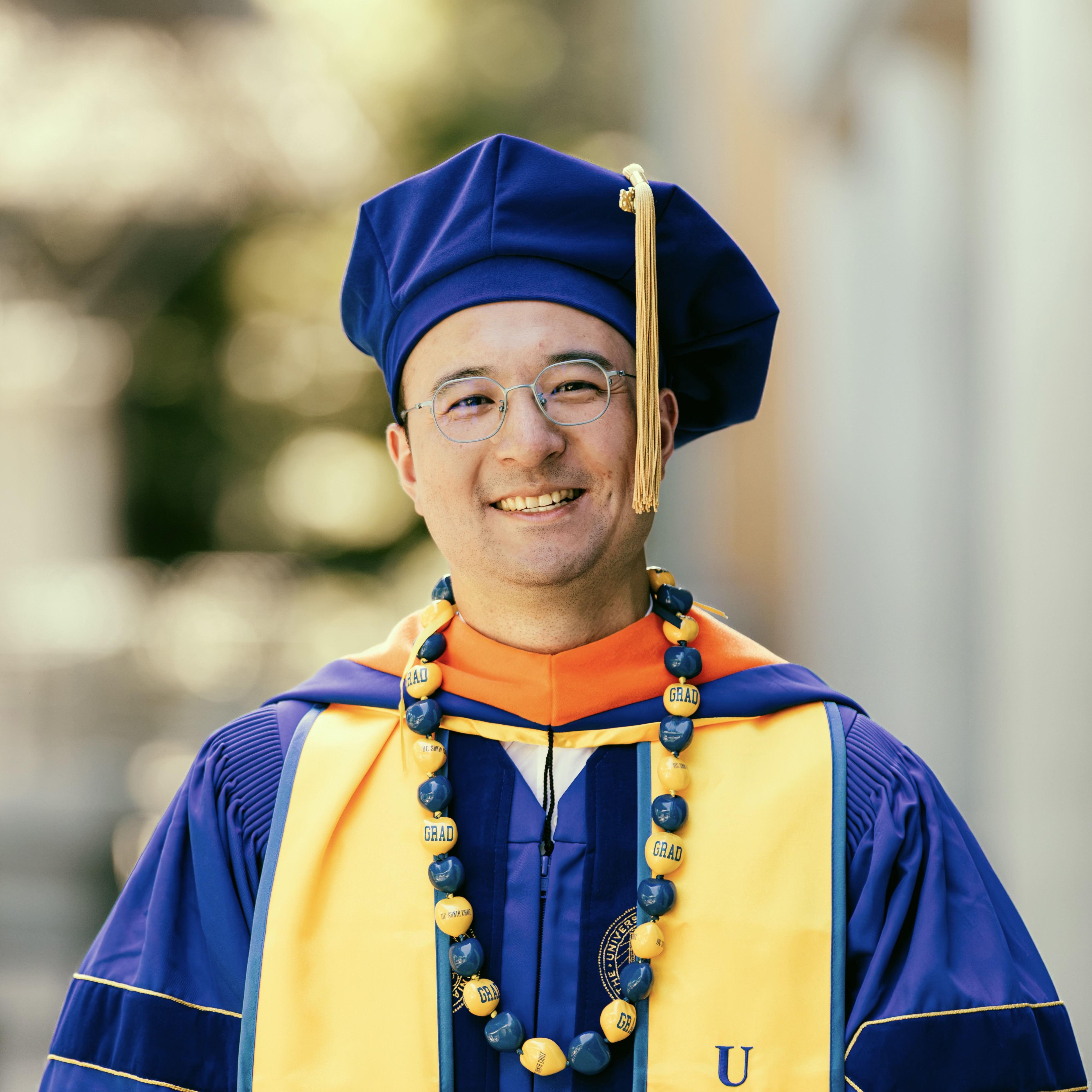 A portrait of Gan Shen wearing PhD regalia